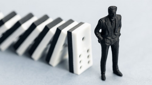 Domino effect concept. Dominoes falling and putting a company or