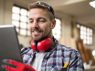 Portrait of middle aged professional worker carpenter with ear p
