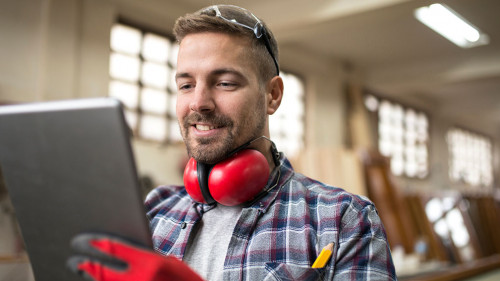 Portrait of middle aged professional worker carpenter with ear p