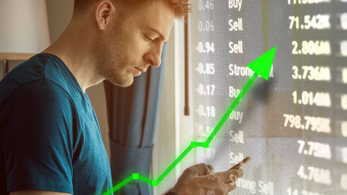 Man on mobile device for trading and stock market upward trend.