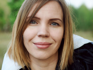 Middle-aged woman in a jacket on the street in the park.