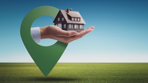 Hand holding a model house