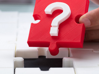 Person placing question mark piece into jigsaw puzzle