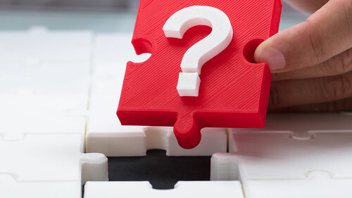 Person placing question mark piece into jigsaw puzzle