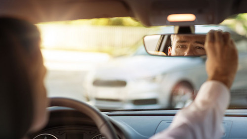 Man adjusting a rearview mirror