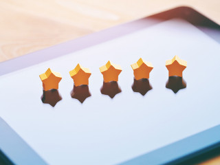 five stars rating symbol as product feedback on tablet computer