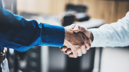 Business partnership handshake concept.Closeup photo of two businessmans handshaking process.Successful deal after great meeting.Horizontal, blurred background.
