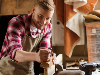 carpenter working with plane and wood at workshop