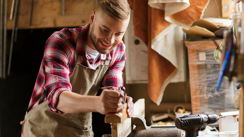 carpenter working with plane and wood at workshop