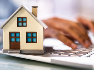 Real Estate House Model Near Laptop