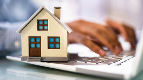 Real Estate House Model Near Laptop