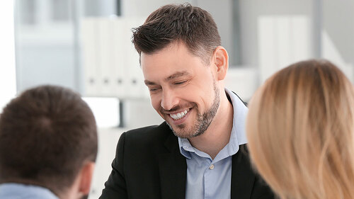 Businessman consulting young couple in office