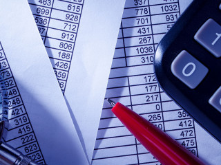 Calculator and Pen on Top of Paper Reports