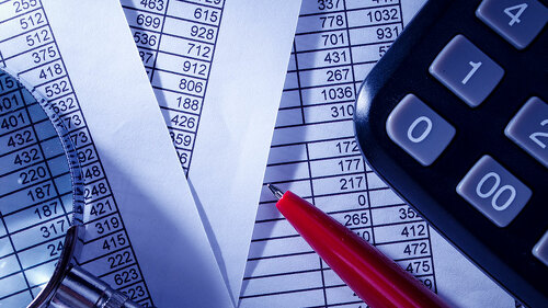 Calculator and Pen on Top of Paper Reports