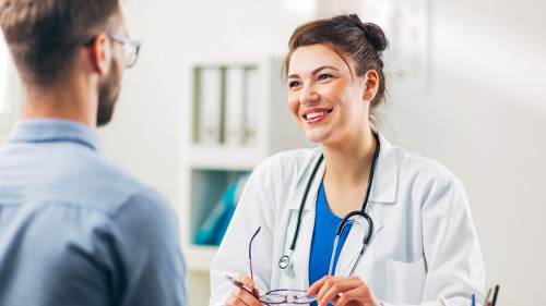 Woman Doctor talking to Patient at her Medical Office