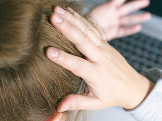 Stressed businesswoman touching head with hands and looking at t