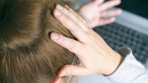 Stressed businesswoman touching head with hands and looking at t