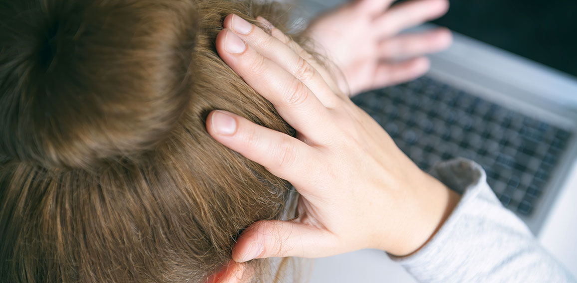 Stressed businesswoman touching head with hands and looking at t