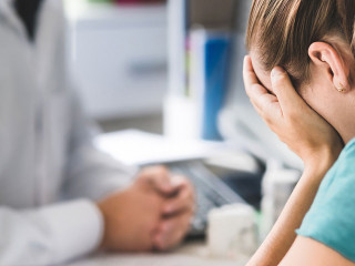 Sad patient visiting doctor. Young woman with stress or burnout