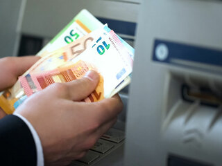 Man counting euros withdrawn from ATM, 24h service, easy banking