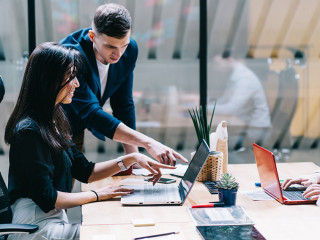 Proud ceo pointing on laptop computer and discussing graphic pre