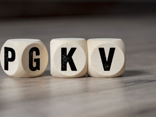 Cubes and dice with the acronyms PKV and GKV on wooden backgroun