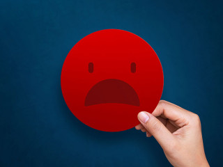 Customer giving bad emoticon for rating on blue background. Serv