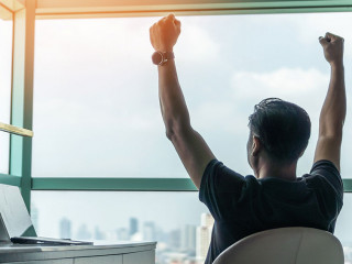 Business achievement concept with happy businessman relaxing in