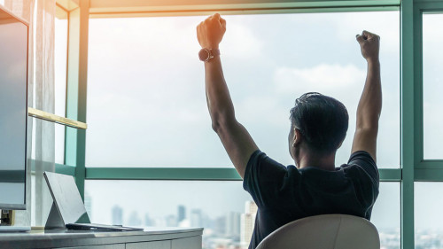 Business achievement concept with happy businessman relaxing in