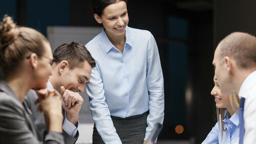 smiling female boss talking to business team