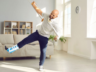 Funny positive man with numerous physical injuries having fun during rehabilitation at home.