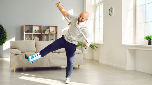 Funny positive man with numerous physical injuries having fun during rehabilitation at home.
