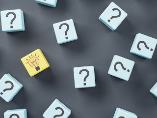 Idea concept with blue wooden cubes with question sign and one yellow with light bulb on dark background