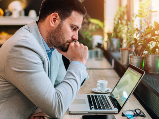 Thoughtful businessman looking at laptop screen
