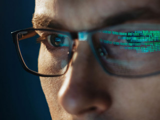 Close-up portrait of focused software engineer wearing eyeglasses