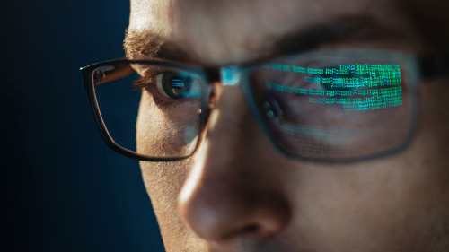 Close-up portrait of focused software engineer wearing eyeglasses