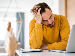 Frustrated young man working on laptop at home