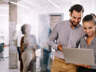 Happy young business people colleagues talking working in office