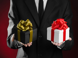 Theme holidays and gifts: a man in a black suit holding two excl