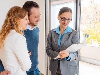 Landlady or realtor showing lease agreement to new tenants