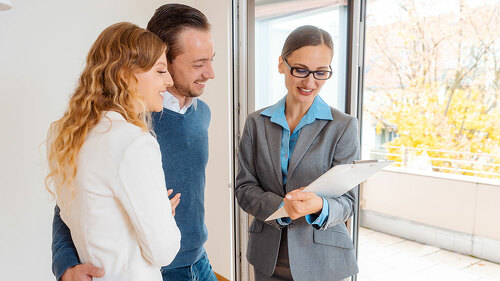 Landlady or realtor showing lease agreement to new tenants