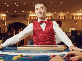 Croupier holds poker cards in his hands at a table in a casino.