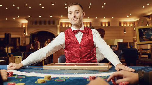 Croupier holds poker cards in his hands at a table in a casino.