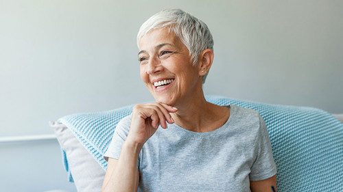 Happy woman relaxing on her couch at home in the sitting room. P