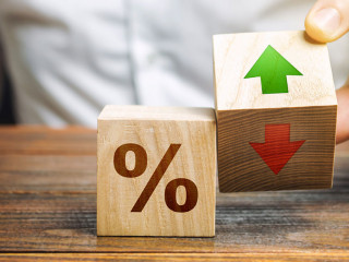 Businessman holds wooden blocks with percent and up or down arrow. Mortgage and loan rates. Interest rate, stocks, ranking. Business and finance concept.