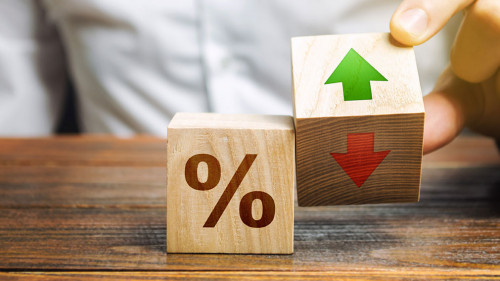 Businessman holds wooden blocks with percent and up or down arrow. Mortgage and loan rates. Interest rate, stocks, ranking. Business and finance concept.