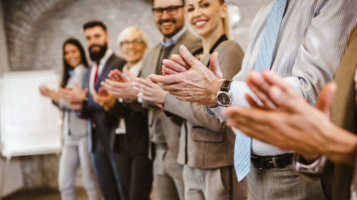 Great job! Successful business team is clapping their hands in m