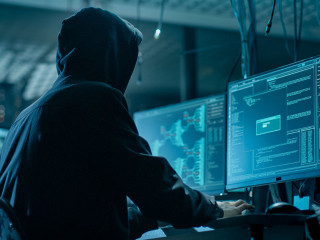 Shot from the Back to Hooded Hacker Breaking into Corporate Data