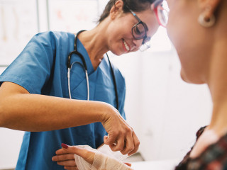 Professional nurse at the hospital bandaging the hand with a med