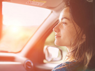 Beautiful woman smiling while sitting on the front passenger seats in the car